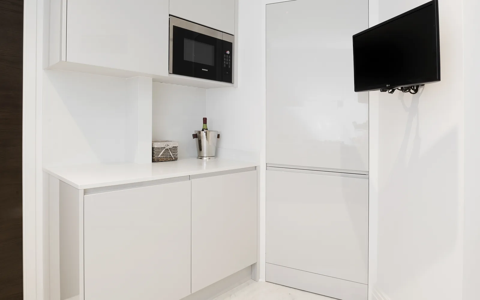 Fitted kitchen utility storage with integrated microwave and tall cabinetry