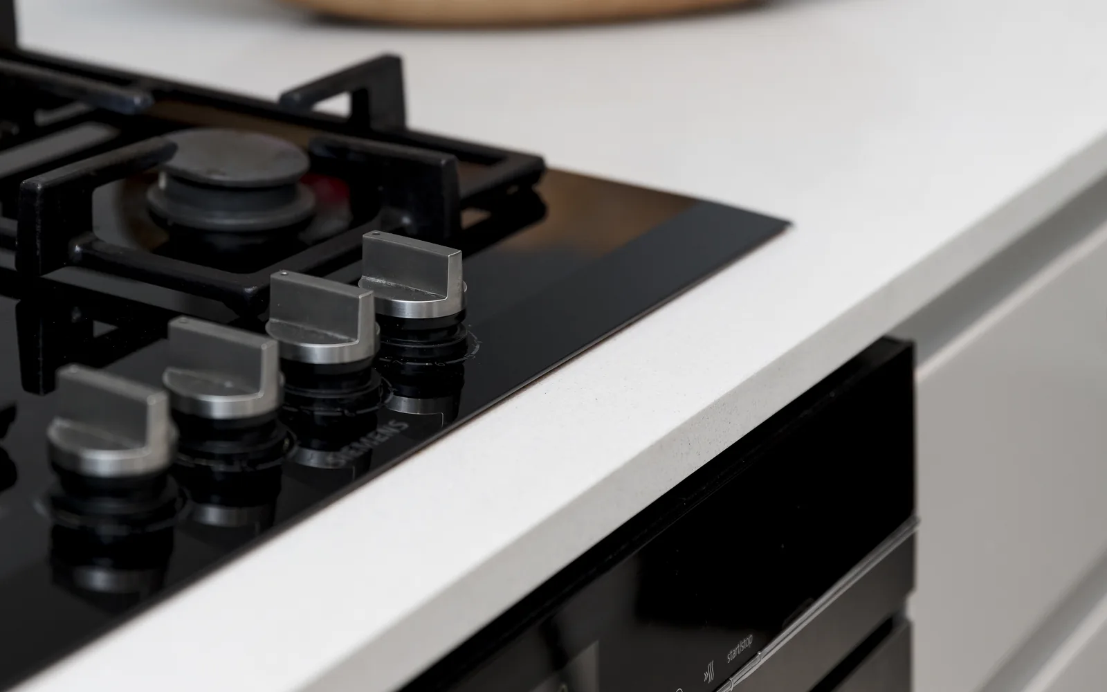 Close-up of a fitted kitchen worktop, gas hob and integrated oven installation detail